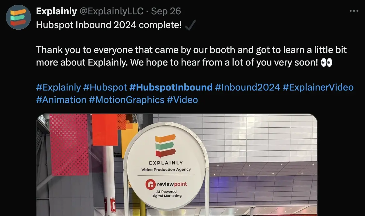 A booth display featuring Explainlys logo and a sign promoting their video production services at an event.